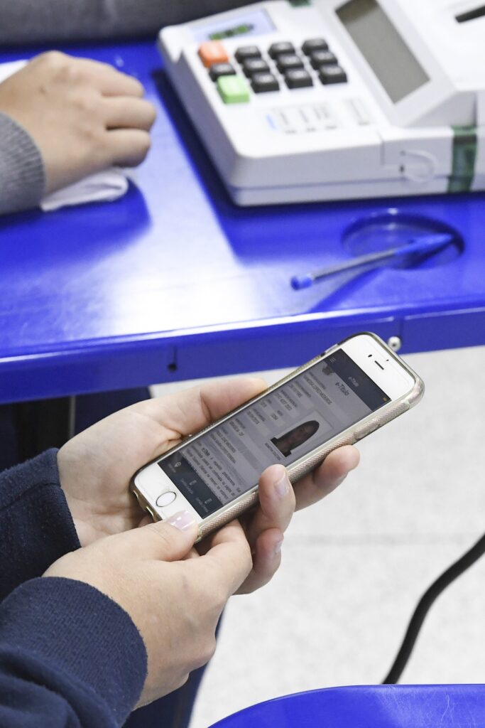 Onde eu voto: eleitor mostra o e-Título no celular na mesa receptora