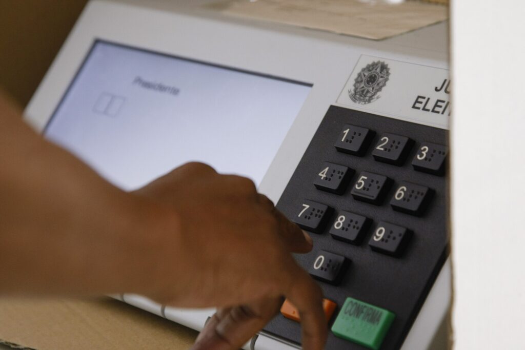 Eleitor digita o voto na urna eletrônica, onde estão os 13 candidatos a presidente