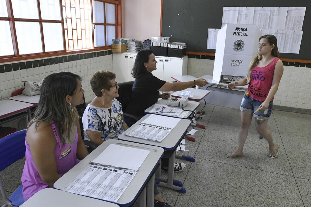 Eleitora segue para a cabine, onde a colinha eleitoral de papel pode entrar