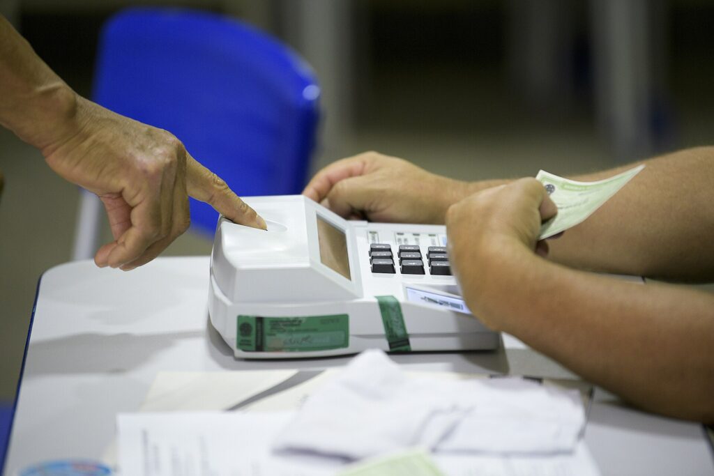 Documentos para votar: mesário confere o documento do eleitor na mesa receptora